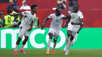 El centrocampista senegalés Pape Gueye (n.º 26) celebra con sus compañeros, el delantero Sadio Mané (n.º 10) y el defensa Ismail Jakobs (n.º 14), tras marcar el tercer gol de su equipo.
