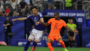 Crysencio Summerville (d) de Países Bajos disputa el balón con Hiroki Ito de Japón.