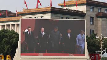 Una pantalla muestra al presidente chino, Xi Jinping (c); al presidente ruso, Vladimir Putin (3-i), y al líder norcoreano, Kim Jong Un (3-d), llegando a un desfile militar en Pekín, China.