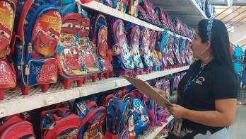 Funcionaria de la Acodeco monitorea precios de útiles escolares.
