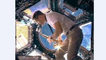 Astronauta tocando sax en la estación espacial europea durante el acto de bienvenida de los próximos juegos de verano.