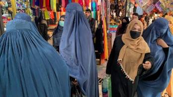 Mujeres vestidas con burka y hiyab (o pañuelo) islámico en un mercado de Kabul.