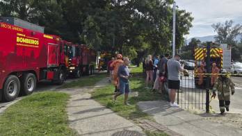Fotografía cedida este 14 de junio por Roberta Durço que captó a integrantes de los bomberos al trabajar en la zona donde cayó uno de los dos helicópteros que colisionaron este domingo en el aire, en el barrio Recreio dos Bandeirantes, en Río de Janeiro (Brasil).
