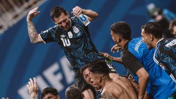 Messi es levantado por sus compañeros.