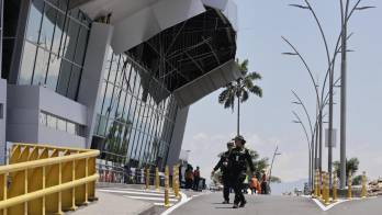 Un par de policías fue captado este 11 de agosto al caminar frente a la fachada del Aeropuerto Internacional Matecaña, visiblemente afectado tras el terremoto de magnitud 7,4 que sacudió en la víspera a Colombia, en Pereira (Colombia). EFE/Carlos Ortega