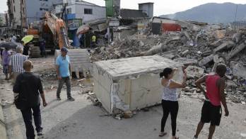 Personas observan este miércoles un edificio destruido por el terremoto de magnitud 7,4 en Dosquebradas Risaralda (Colombia).