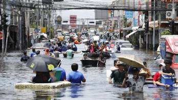 Este martes 29 de septiembre, residentes tailandeses atravesaban las aguas de la inundación para recoger alimentos y artículos de primera necesidad en el Rom Klao Community Housing.