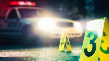 police car at a crime scene with evidence markers, high contrast image