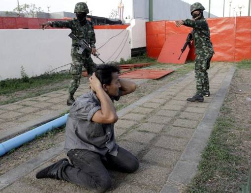 Soldados tailandeses arrestan a protestante.