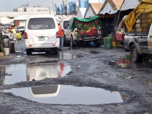 Compradores y vendedores tienen que lidiar con las aguas estancadas en la calle.