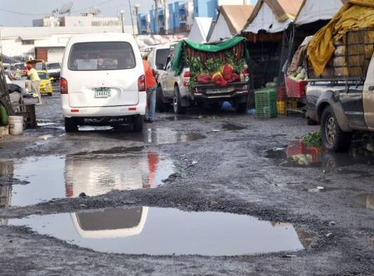 Compradores y vendedores tienen que lidiar con las aguas estancadas en la calle.