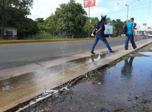 Los transeúntes tenían que chifear el charco de agua que cubría la vereda.