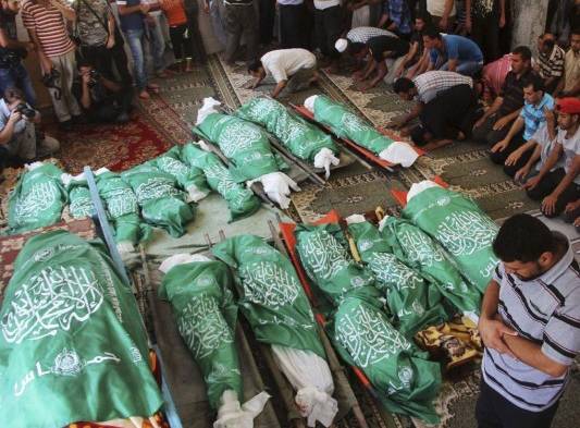 Palestinos oran sobre los cuerpos envueltos en banderas de Hamas de los miembros de la familia Abu Jamea, durante su funeral en la mezquita principal de Khan Younis.