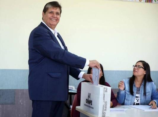 El candidato presidencial por el partido Alianza Popular, Alan García (i), emite su voto en un centro de votación en el distrito de Miraflores, en Lima, Perú.