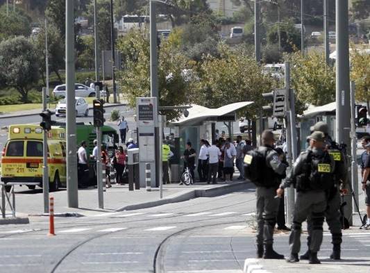 Miembros de las fuerzas de seguridad israelíes permanecen en la estación de tren ligero de la Colina de la Munición, sitio de un tiroteo, en la ciudad de Jerusalén