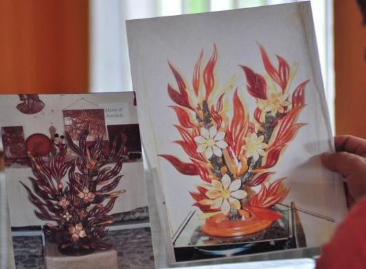 Arreglo floral es plasmado en papel para luego hacerlo con gubias en pedazos de tronco.