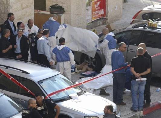 Personal sanitario cubre el cuerpo de una de las víctimas tras el ataque contra una sinagoga en Jerusalén (Israel)..
