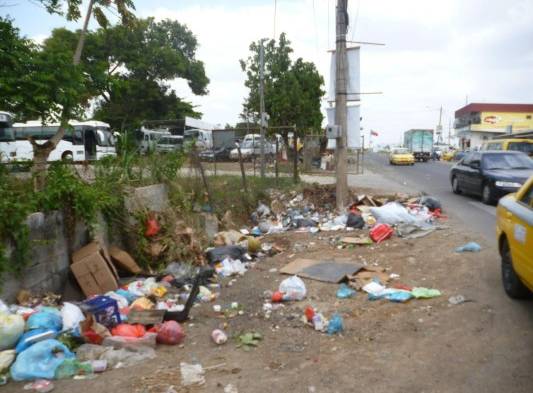 Algunas personas tiran desechos frente al minisúper Multicarnes.
