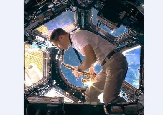 Astronauta tocando sax en la estación espacial europea durante el acto de bienvenida de los próximos juegos de verano.