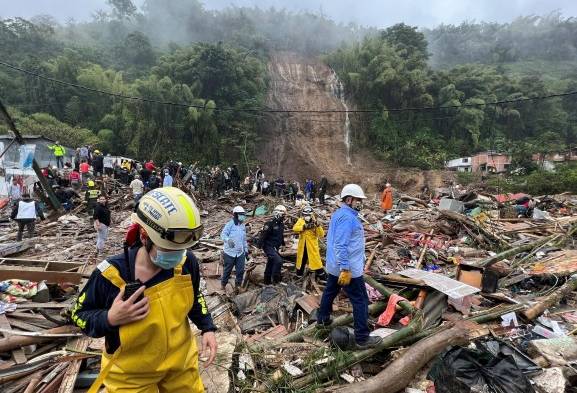 Autoridades y miembros de cuerpos de rescate trabajan en una zona afectada por un deslizamiento de tierra causado por las fuertes lluvias que afectan la ciudad de Pereira.