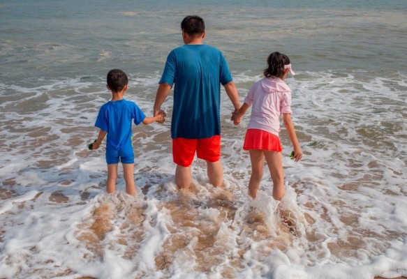 Un padre con sus dos hijos en una playa de Dalian, en el noreste de China.