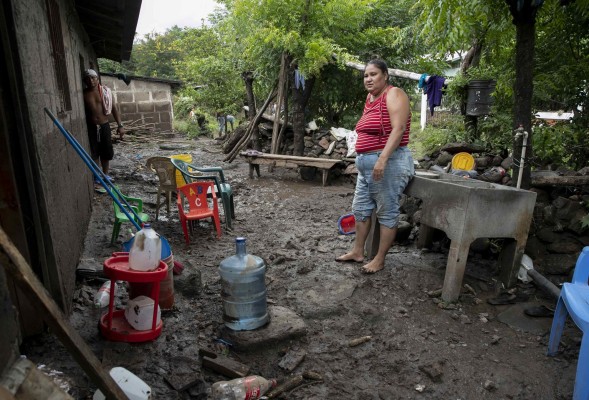 Una mujer limpia hoy su casa afectada por el desbordamiento del río Teutepe tras el paso de la tormenta tropical Julia, en la ciudad de Bluefields (Nicaragua).