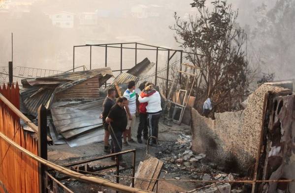 Los residentes de pie junto a sus casas destruidas por un incendio en Valparaíso.