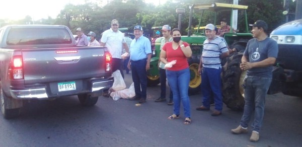Los productores entregaron maíz pilado a los conductores en la vía mientras protestaban.