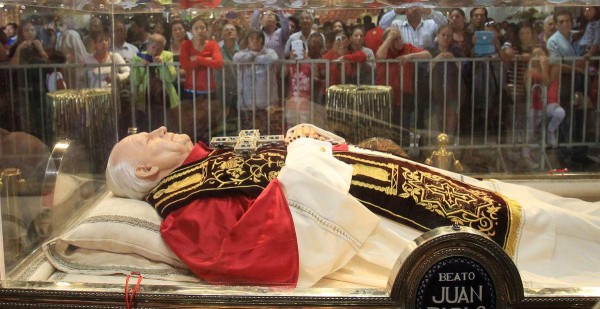 Fieles oran ante una imagen del papa Juan Pablo II en la Ciudad de México.