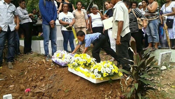 El pequeño hijo de José Luis Quintero Camargo colocándole flores a la tumba de su padre.