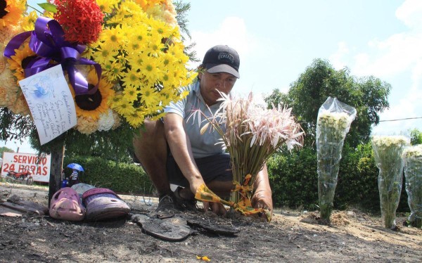 Una persona pone flores en el suelo durante una ceremonia en la que se rindió homenaje a las víctimas del incendio del autobús, en el municipio de Fundación.