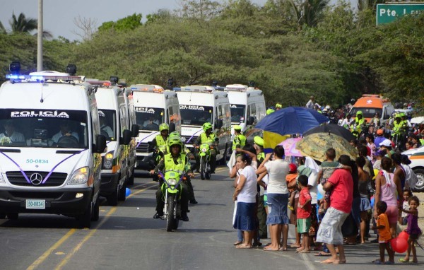 Una gran cantidad de personas salieron a las calles a ver la caravana y a despedirse con flores blancas de los niños quemados dentro de un autobús escolar.
