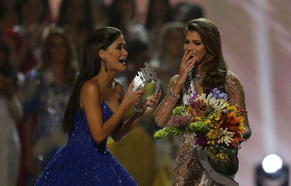 Pia Wurtzbach (i) Miss Universo 2015, entrega la corona a Iris Mittenaere (d), Miss Francia.