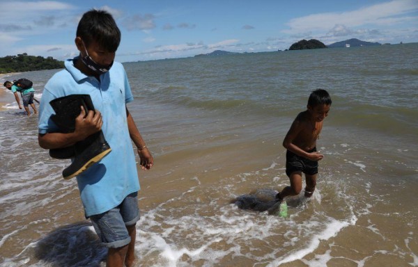 Jóvenes buscan entre la arena conchas y hasta aprovechan las aguas para darse un ‘chapuson' y refrescarse.