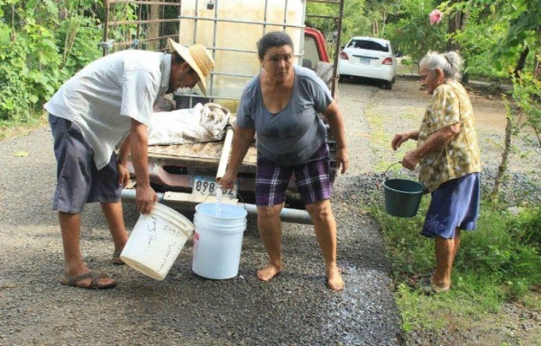 Hasta las personas mayores cargan sus tanques de agua.