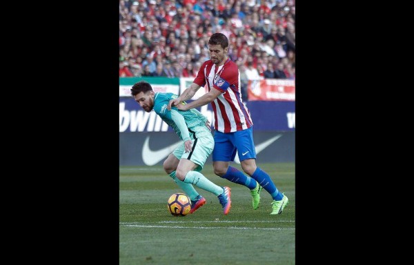 Gabi (d), de Atlético de Madrid, disputa el balón con Lionel.