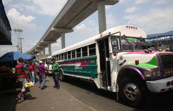 Un ‘diablo verde' espera por pasajeros en una parada de San Miguelito.