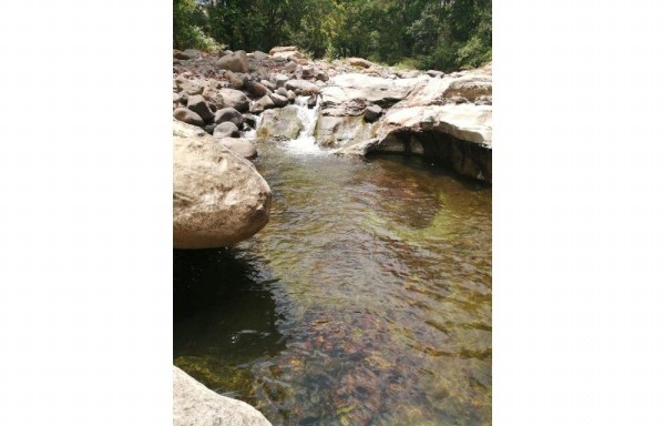 A lo largo del río están las piscinas.