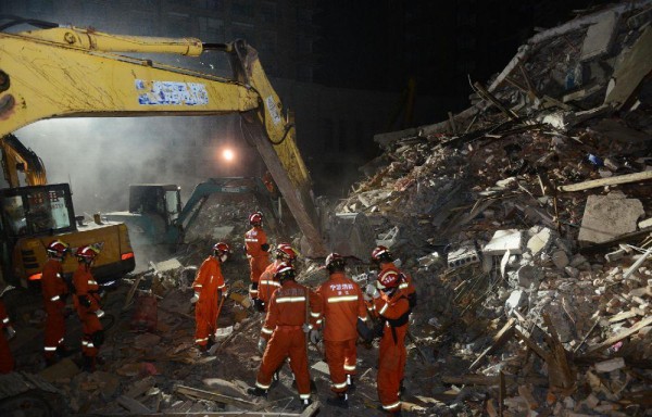 Los rescatistas buscan sobrevivientes con ayuda de maquinaria en el sitio de un colapso de edificios.