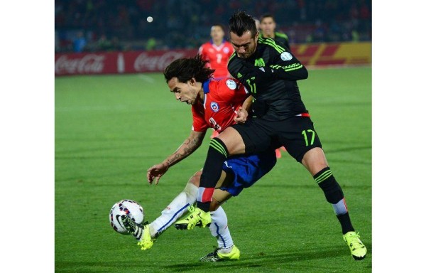 El chileno Jorge Valdivia pelea el esférico contra el mexicano Mario Osuna.