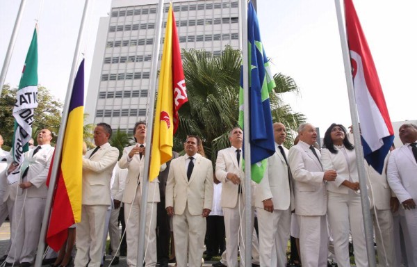 Diputados al momento de izar las banderas de sus partidos.