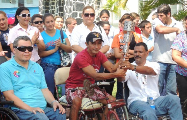 Uno de los deportistas recibe la antorcha.