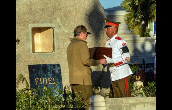 El presidente de Cuba, Raúl Castro coloca en la tumba la urna con las cenizas del líder cubano Fidel Castro