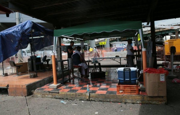 Barberos realizan cortes al aire libre.