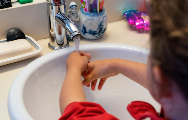 Una niña se lava las manos en una fotografía de archivo.