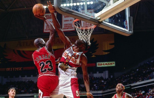 Dikembe Mutombo (d) taponando a Michael Jordan.