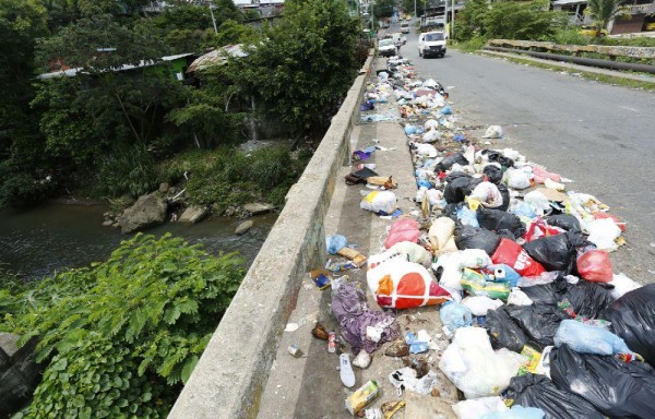 Desechos arrojados en un puente sobre el río Palomo.
