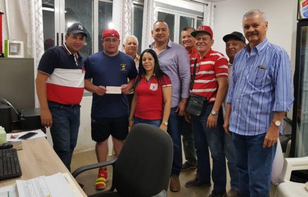 El receptor chiricano Carlos Ruiz retirando su cheque de $40 mil.