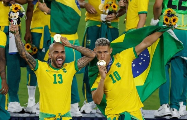 Richarlison (d) y Dani Alves (i) celebran.