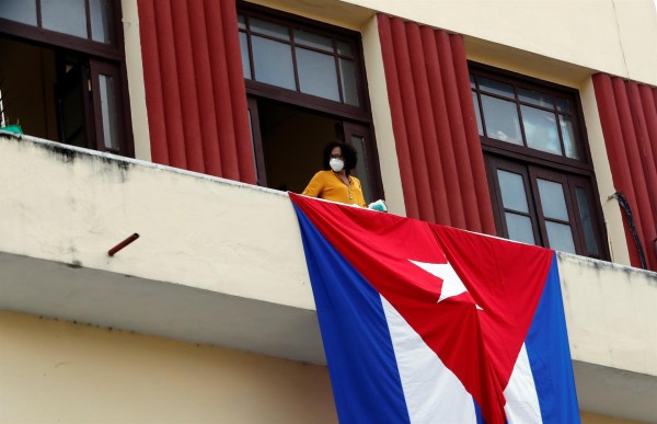 Una mujer sale al balcón donde se expone una bandera cubana, hoy en La Habana, Cuba.